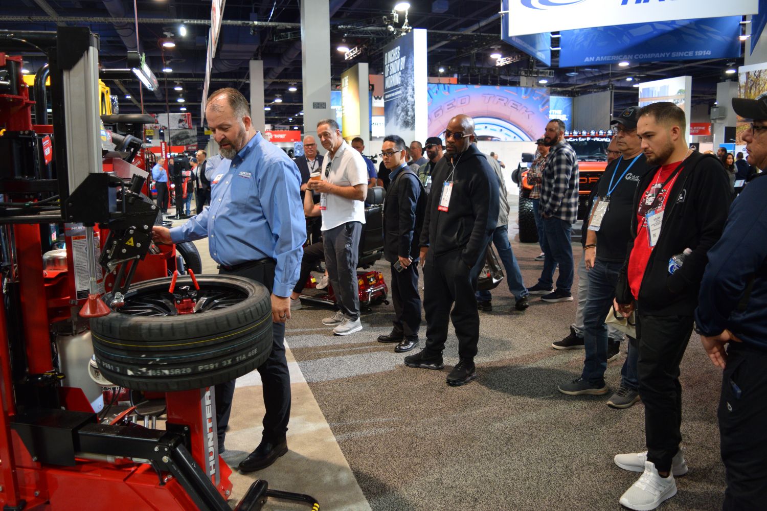 Attendees watch a wheel and tire service equipment demonstration at the SEMA Show