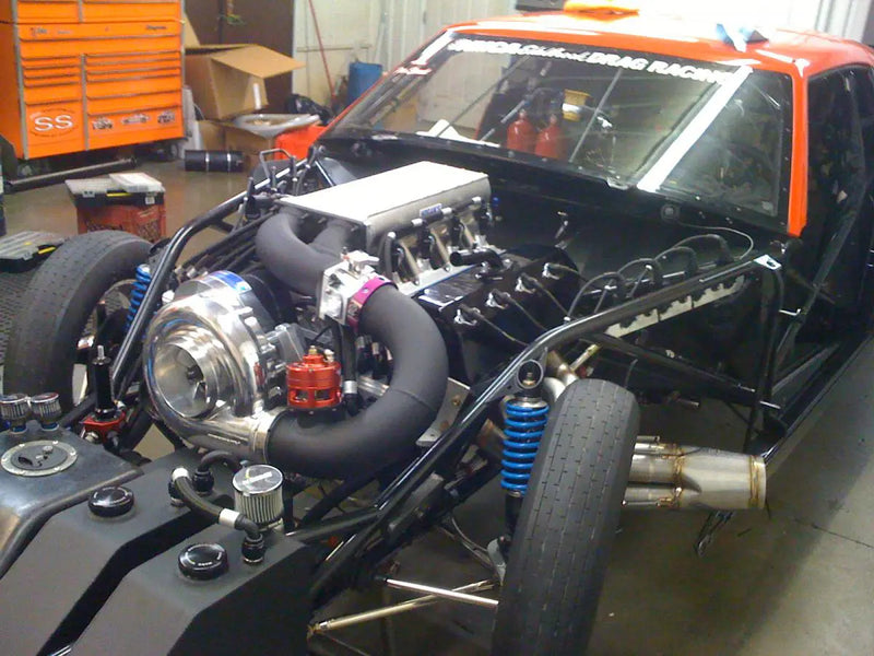Manufacturer F-3 race-installation example with custom chassis and charge plumbing. Illustrative only; exact head, engine, rotation, mounting and supplied kit hardware must match the selected configuration.